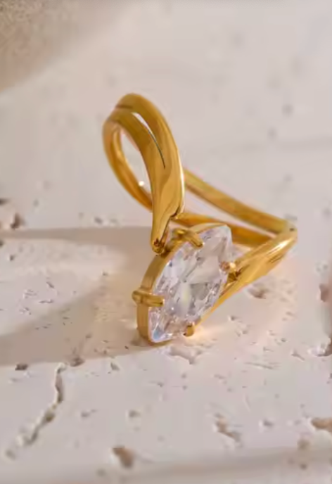 Elevate your jewelry ritual with the Halo Ring—featuring a marquise-cut crystal, luxe gold-plated finish, and sculptural design perfect for stacking or standing alone.