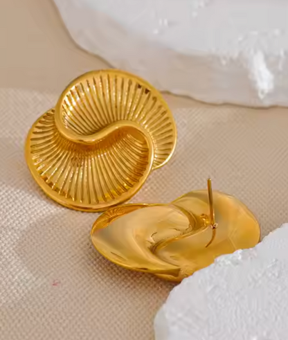 Gold-plated sculptural earrings inspired by conch shells, featuring a wavy, ridged design from the RESORT 444 Luxe Latitude Collection.